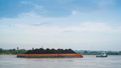 Kapal tongkang mengangkut hasil tambang batubara melintasi sungai Mahakam di Kabupaten Kutai Kartanegara, Kalimantan Timur. Foto Dok Rienews.com