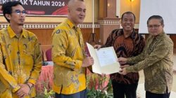 Ketua KPU Karo Rendra Gaulle Ginting menyerahkan hasil SK rekapitulasi kepada pasangan Antonius Ginting dan Komando Tarigan terpilih sebagai Bupati-Wakil Bupati Karo dalam Pemilkada 2024. Foto Rienews.com.