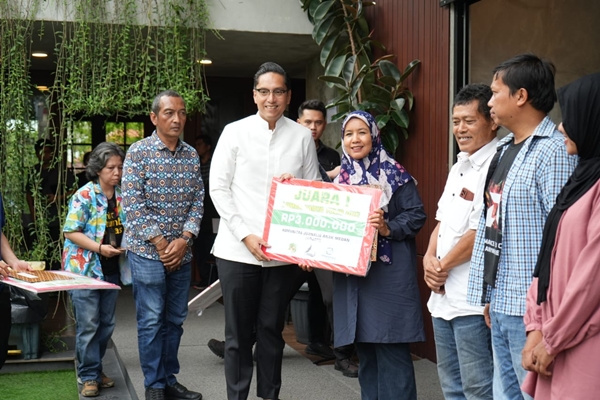 Wali Kota Medan Rico Tri Putra Bayu Waas menyerahkan hadiah kepada Yuni Naibaho (waspada.id) pemenang pertama karya tulis jurnalis bertema: Mengubah Musibah Menjadi Berkah dengan UHC-JKMB, Sabtu, 8 Maret 2025. Foto Istimewa.